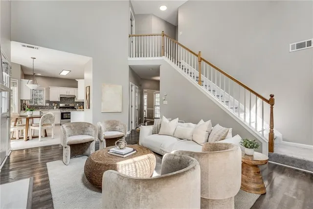 a living room with furniture and a dining table with wooden floor