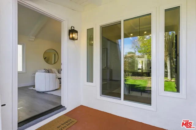 a living room with furniture a chandelier and a potted plant
