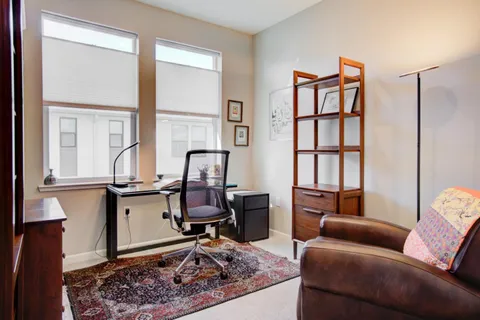 a living room with furniture a rug and a window