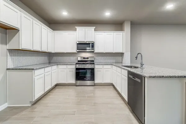 a kitchen with stainless steel appliances granite countertop a sink and cabinets