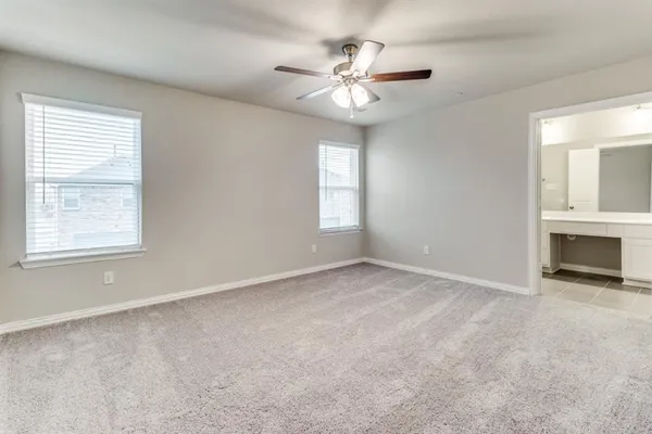an empty room with windows and fireplace