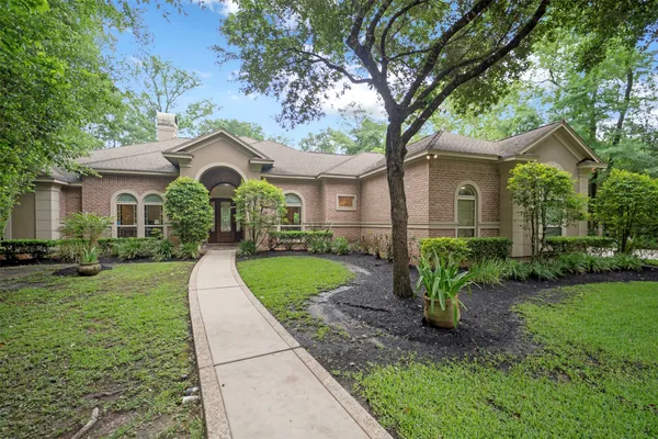 a front view of a house with a yard and trees