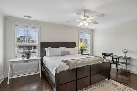 a bedroom with a bed and a table with wooden floor