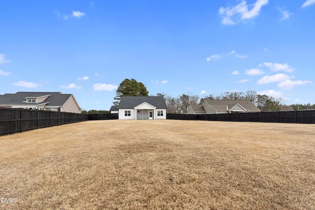 a view of an empty room with window a ceiling fan and wooden floor