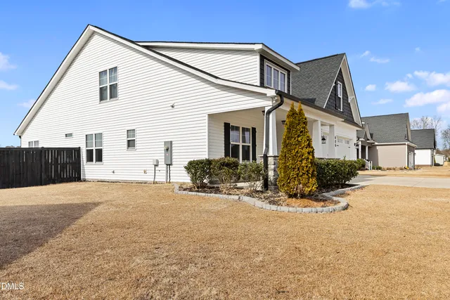 a view of a house with a big yard and garage