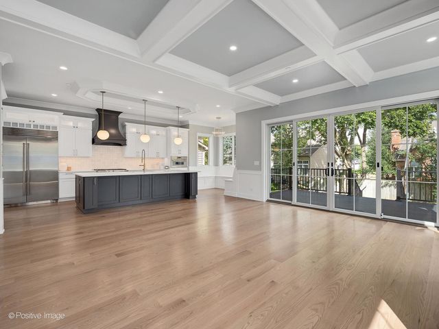 an empty room with wooden floor and a large window