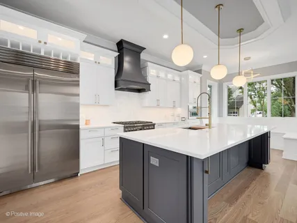 a kitchen with a sink stainless steel appliances a large counter space and cabinets