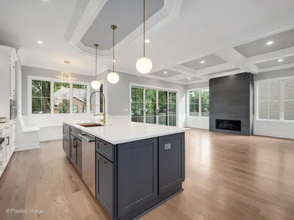 a kitchen with a stove and wooden floor