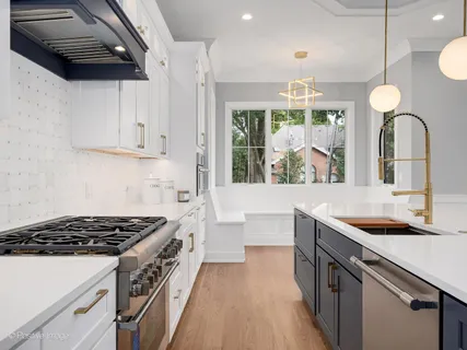 a kitchen with stainless steel appliances granite countertop a sink stove and cabinets