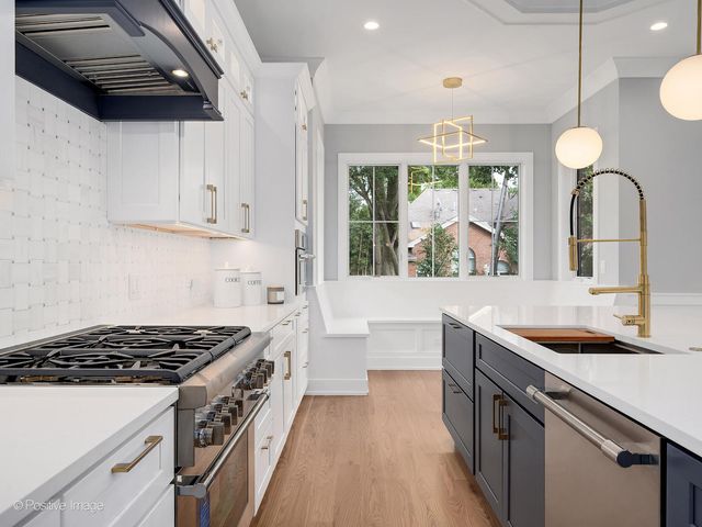 a kitchen with stainless steel appliances granite countertop a sink stove and cabinets