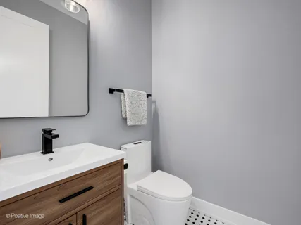 a bathroom with a sink a toilet and mirror