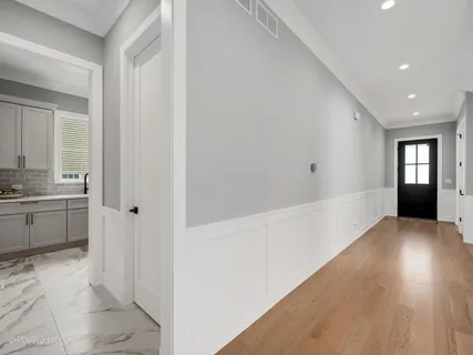 a view of a hallway to kitchen with granite countertop a sink and dishwasher