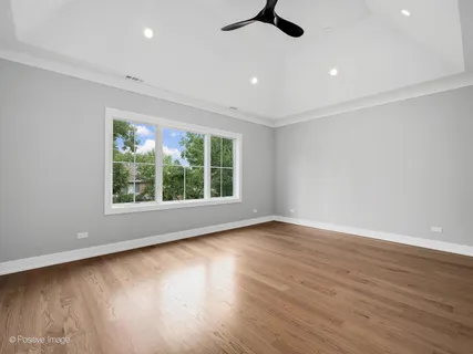 an empty room with wooden floor cabinet and windows