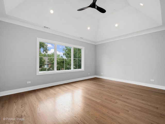 an empty room with wooden floor cabinet and windows