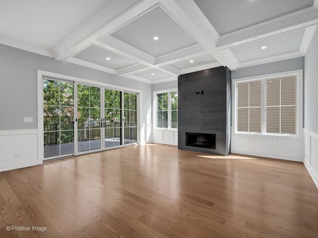 a view of empty room with wooden floor and fireplace