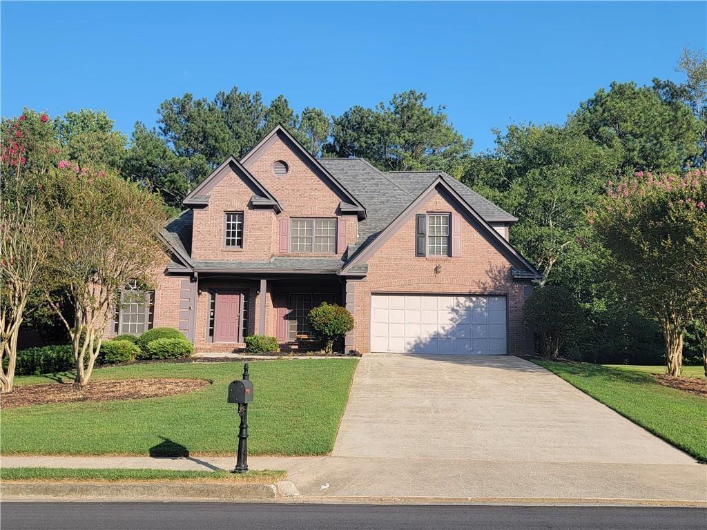 a front view of a house with a yard and trees