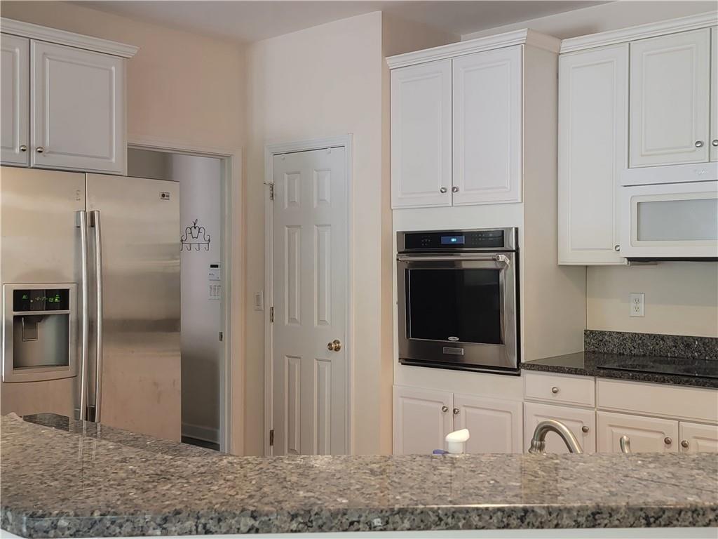 6330 Olde Atlanta Parkway Suwanee, GA 30024 - Photo 11 of 31 a kitchen with granite countertop white cabinets and stainless steel appliances