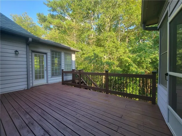 a balcony with wooden floor table and chairs