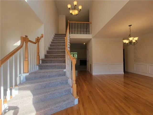 a view of a hallway with wooden floor and staircase