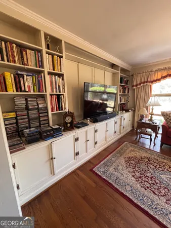 a living room with flat screen tv and a book shelf