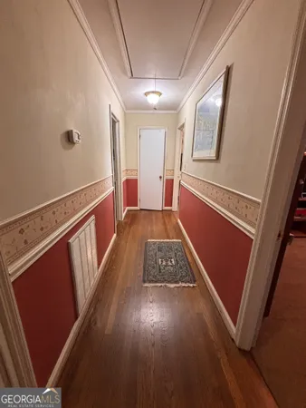 a view of hallway with stairs and wooden floor