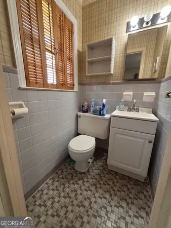 a bathroom with a toilet a sink a window and mirror