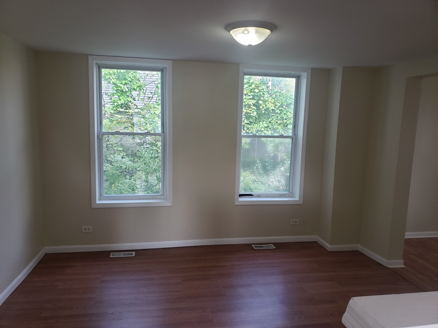 322 North County Street, Unit FRONT Waukegan, IL 60085 - Photo 5 of 15 an empty room with wooden floor and windows