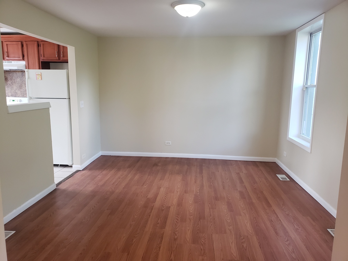 322 North County Street, Unit FRONT Waukegan, IL 60085 - Photo 6 of 15 a view of an empty room with wooden floor and a window