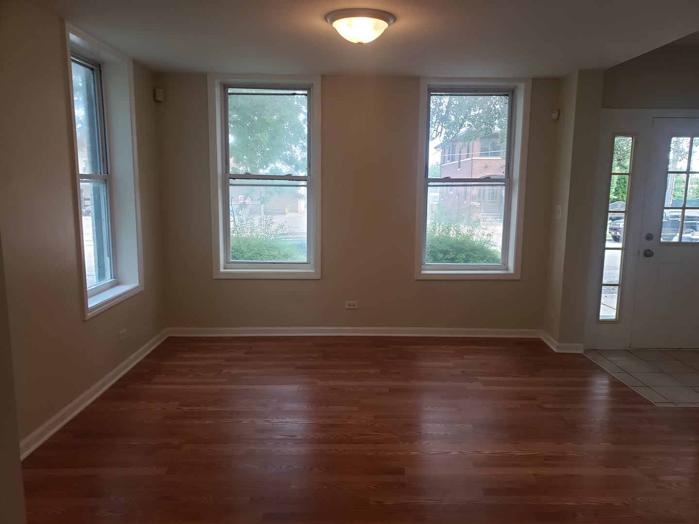 322 North County Street, Unit FRONT Waukegan, IL 60085 - Photo 7 of 15 an empty room with wooden floor and windows