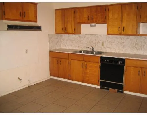 a kitchen with granite countertop a sink cabinets and a wooden floor