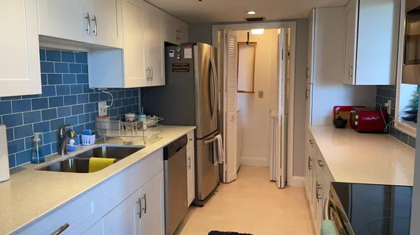 a kitchen with stainless steel appliances granite countertop a sink a refrigerator and a granite counter tops