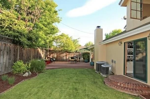 a view of a backyard with plants and outdoor seating