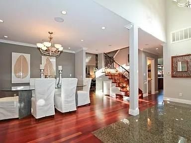 a living room with fireplace chandelier and wooden floor