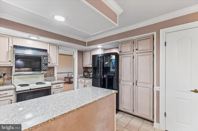 a dining hall with stainless steel appliances a table and chairs