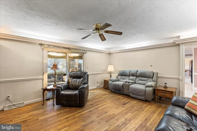 a living room with furniture a flat screen tv and a large window
