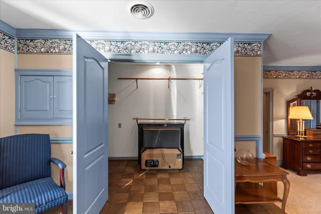 a spacious bedroom with a bed a dresser and window
