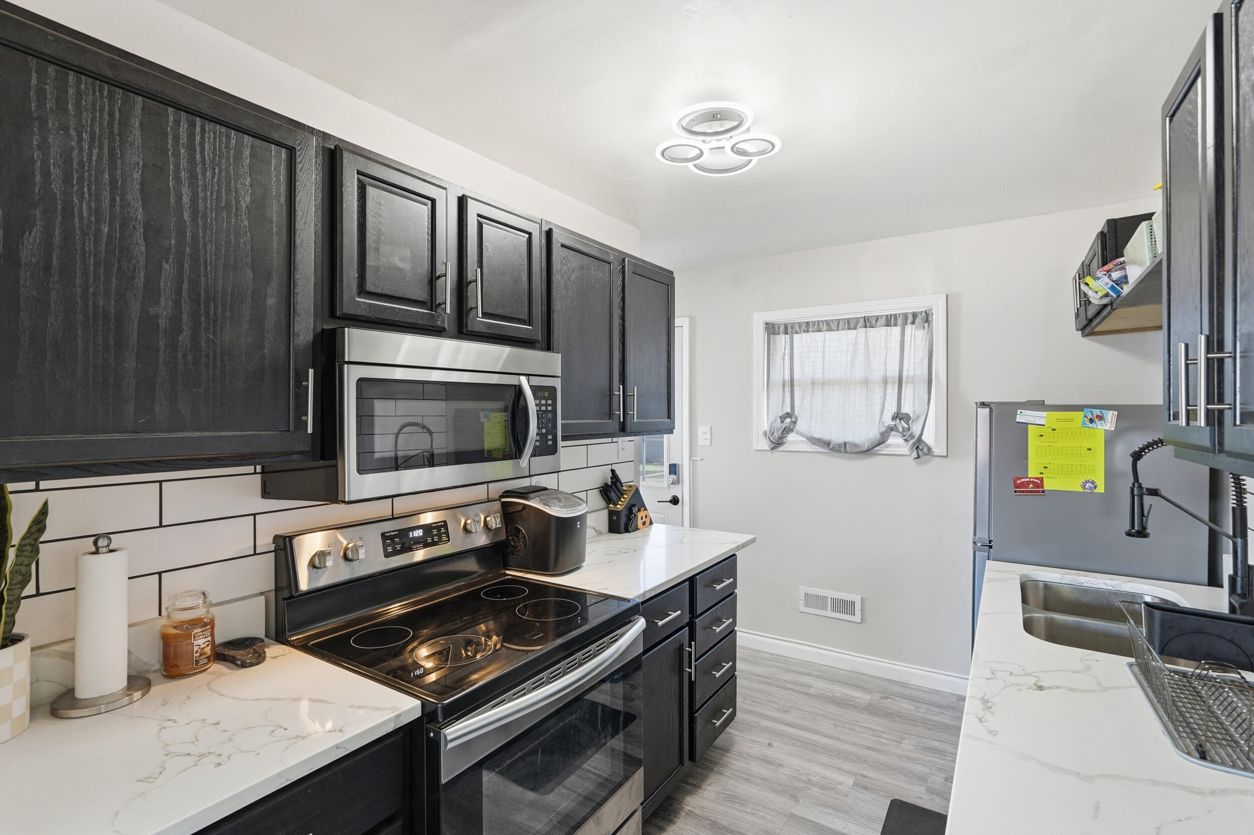 3737 Fillmore Street Gary, IN 46408 - Photo 11 of 19 a kitchen with stainless steel appliances a stove a sink and a microwave