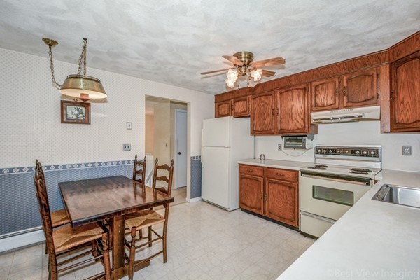 24 Fredrickson Road Billerica, MA 01821 - Photo 8 of 20 a kitchen with stainless steel appliances granite countertop a stove top oven a sink a dining table and chairs with wooden floor
