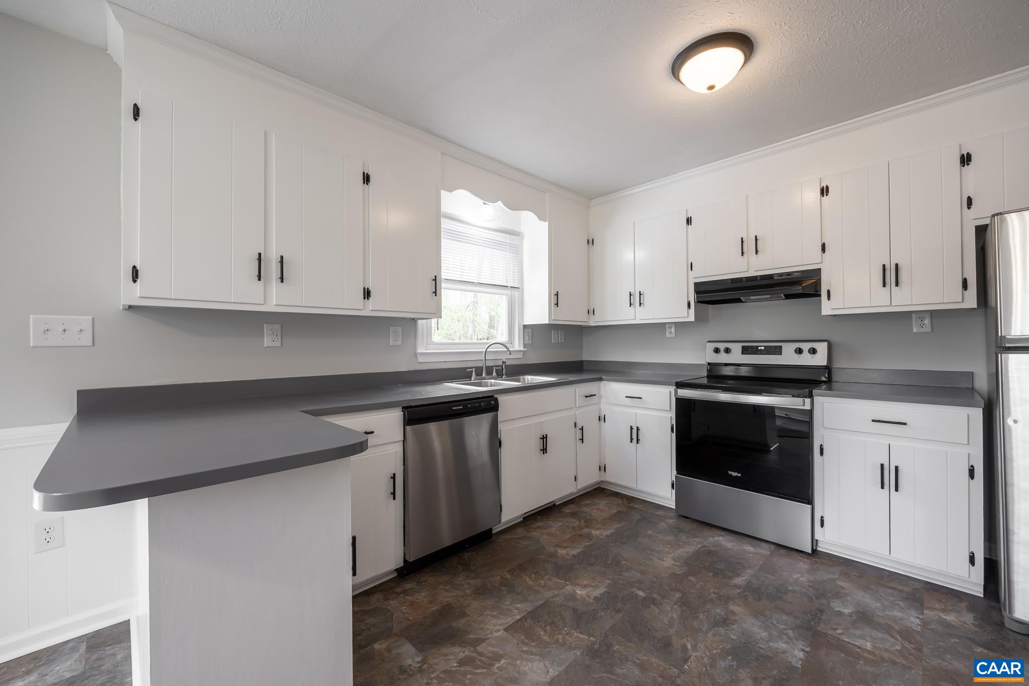 7971 Irish Road Faber, VA 22938 - Photo 4 of 23 a kitchen with granite countertop white cabinets white stainless steel appliances and a sink