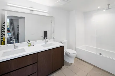a bathroom with a double vanity sink toilet and a mirror