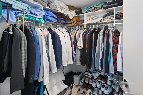 a view of walk in closet with clothes and shoes