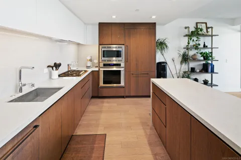 a large kitchen with stainless steel appliances a sink dishwasher stove refrigerator and microwave