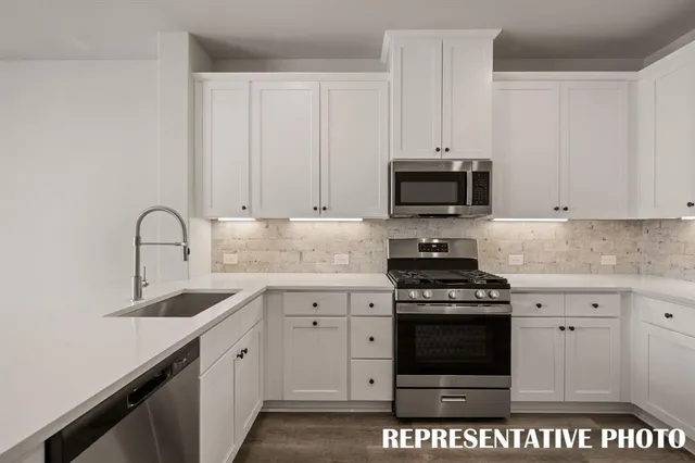 a kitchen with a refrigerator and white cabinets