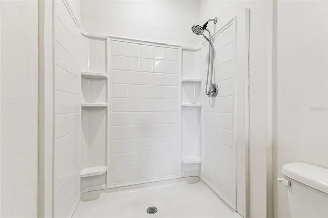 an empty room with a chandelier fan