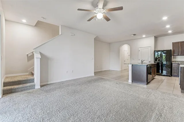 an empty room with a window and a ceiling fan