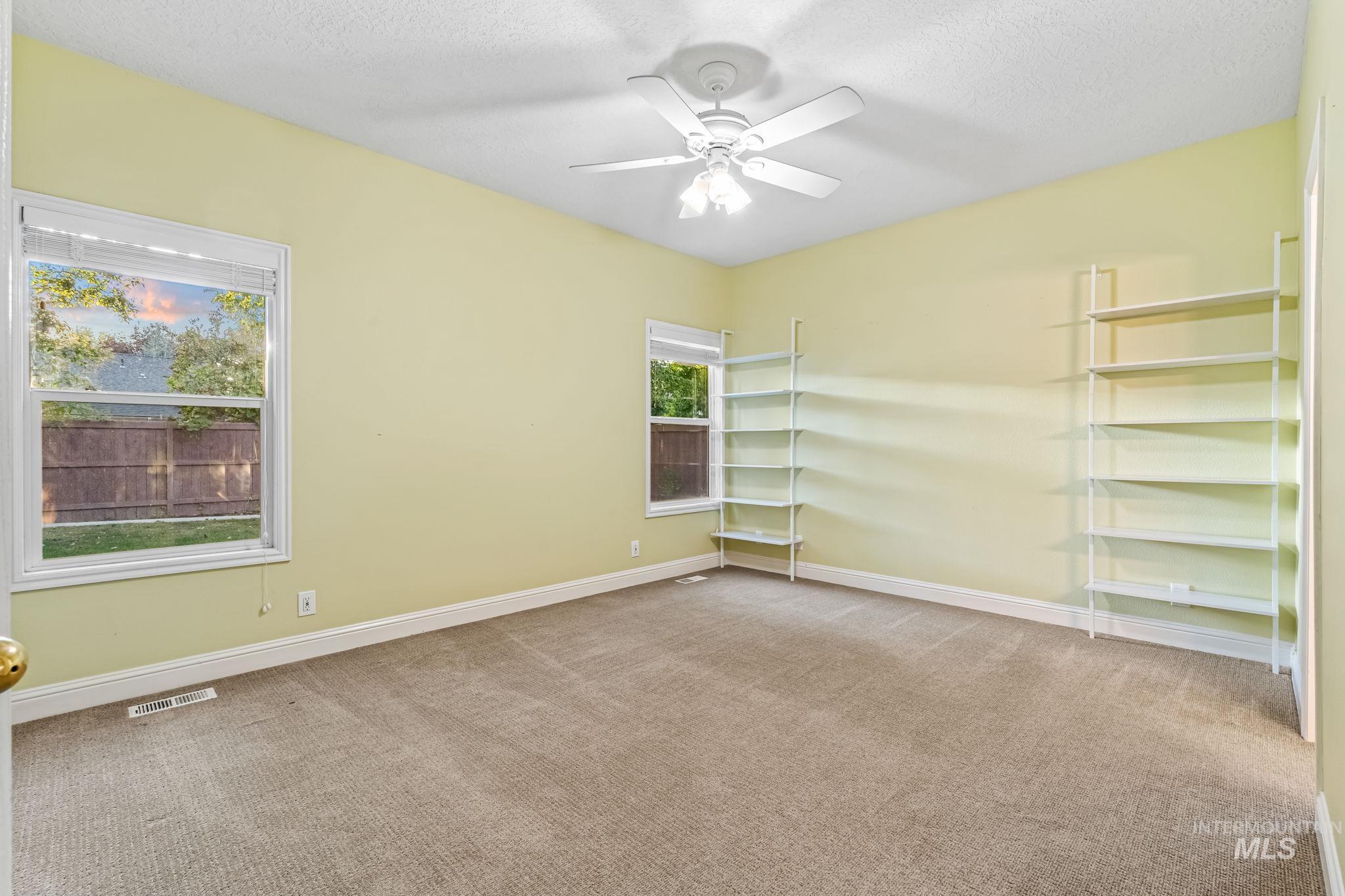 6099 North Heathrow Way Boise, ID 83713 - Photo 14 of 39 Spare room featuring light colored carpet, a ceiling fan, and a textured ceiling