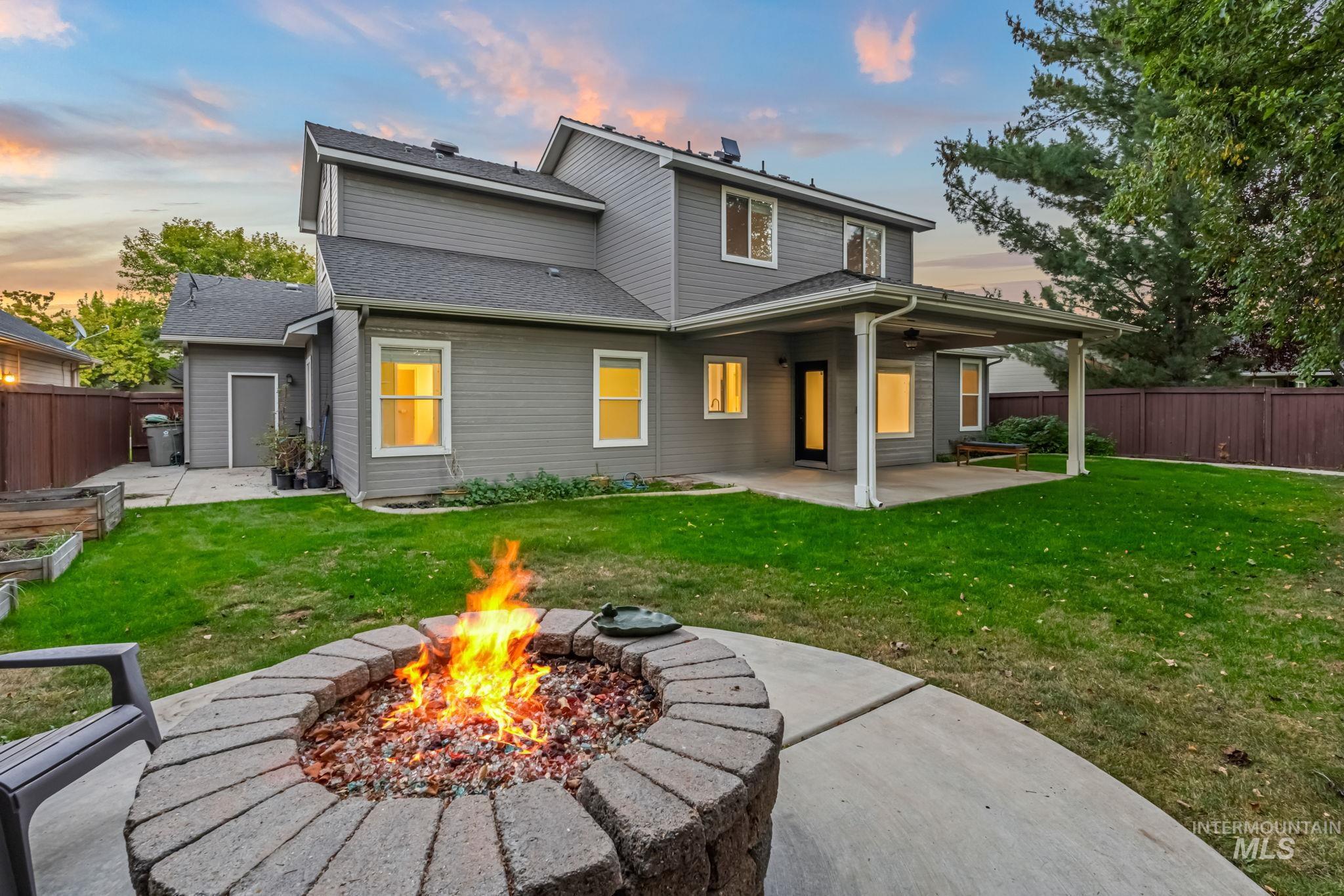 6099 North Heathrow Way Boise, ID 83713 - Photo 33 of 39 Back of house at dusk with a patio area, a fenced backyard, and a shingled roof
