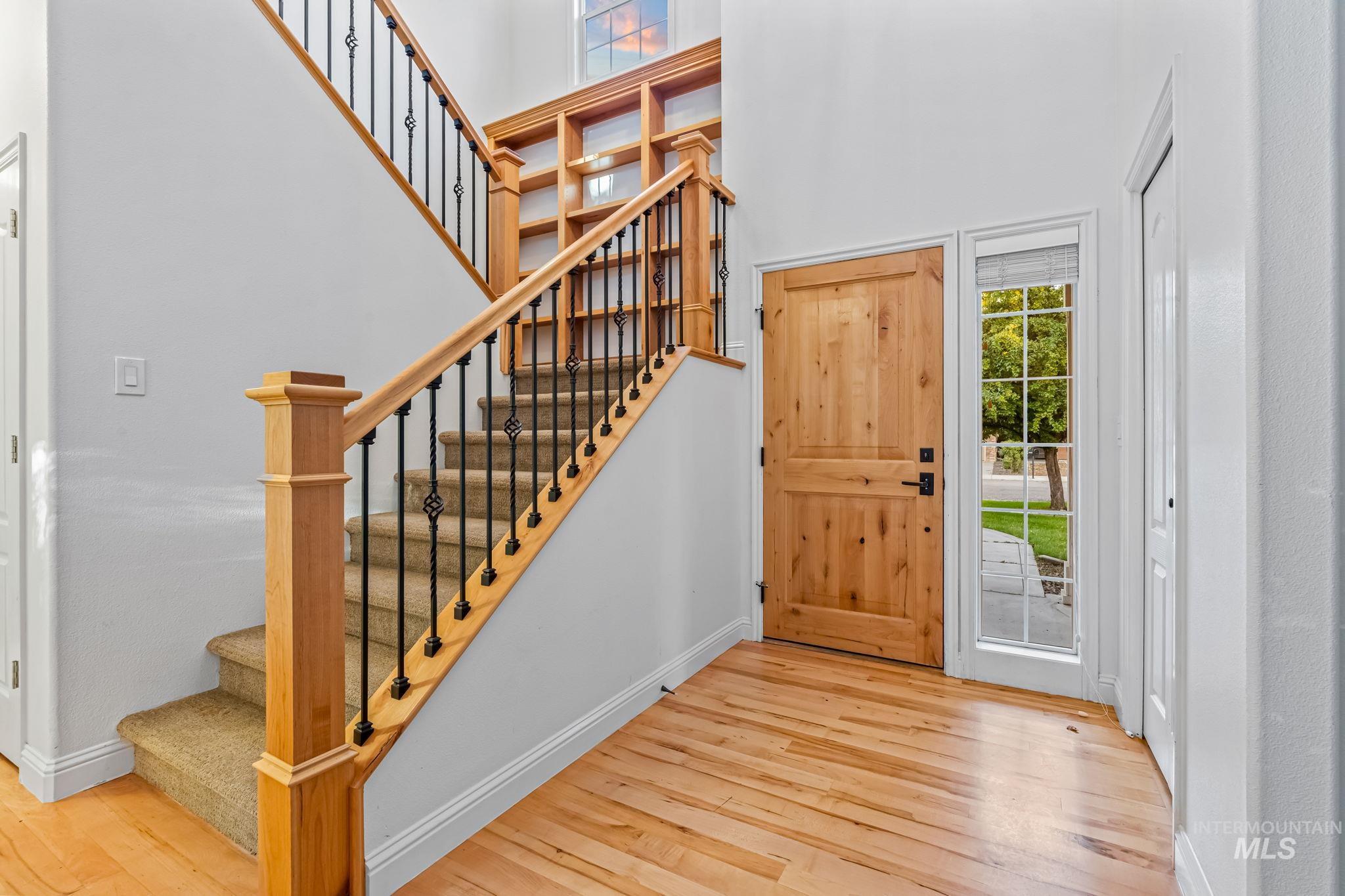 6099 North Heathrow Way Boise, ID 83713 - Photo 6 of 39 Foyer entrance featuring light wood-style flooring, stairs, and a towering ceiling