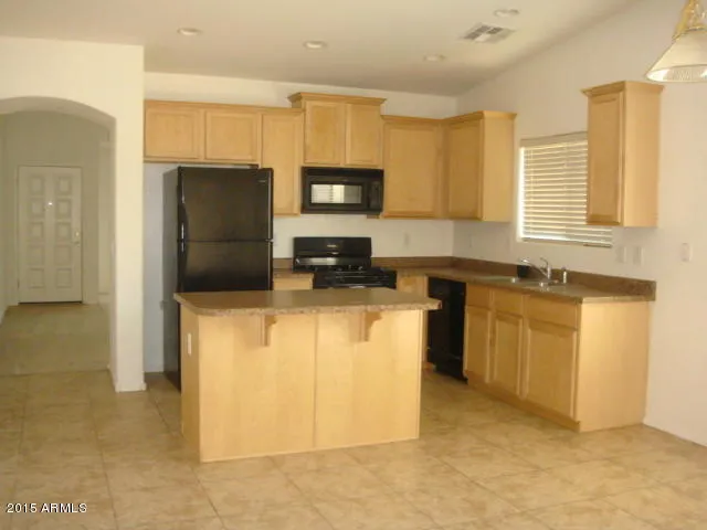 a kitchen with a refrigerator sink and cabinets