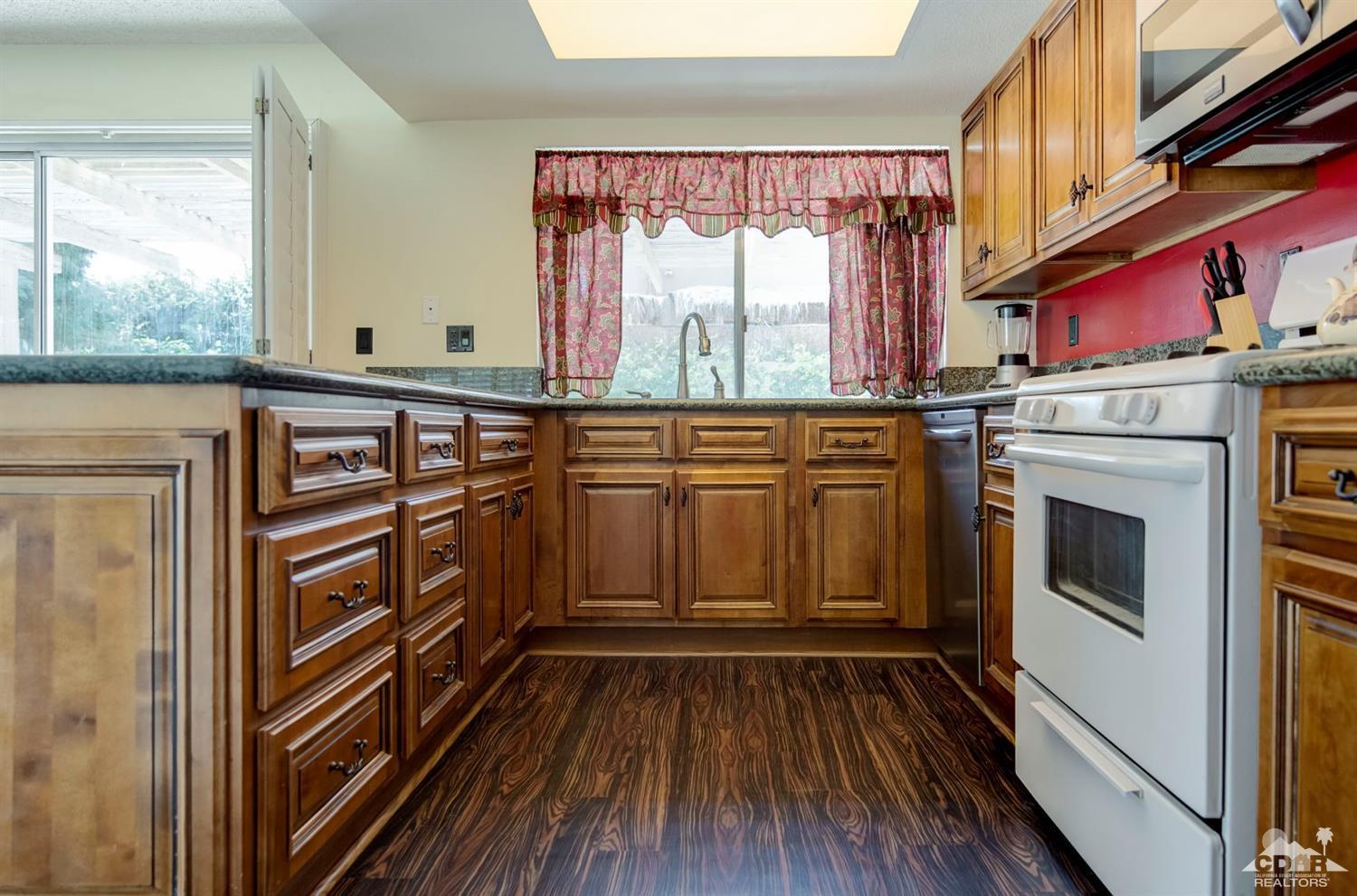 73769 Haystack Road Palm Desert, CA 92260 - Photo 18 of 34 a view of a kitchen with wooden floor and cabinets